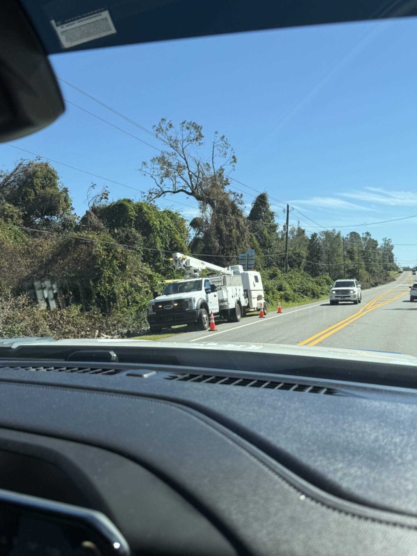 Power utility trucks staged during local recovery work